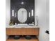 Stylish powder room featuring wooden vanity, marble countertop, vessel sink, and modern tile accent wall at 1616 Turnbull Crossings Dr, New Smyrna Beach, FL 32168