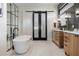This bathroom features a modern tub, dual vanities, and a pass-through to the primary closet at 1616 Turnbull Crossings Dr, New Smyrna Beach, FL 32168