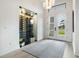 Bright foyer with glass-enclosed wine cellar, modern chandelier, and view of the front yard at 1616 Turnbull Crossings Dr, New Smyrna Beach, FL 32168
