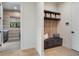 Mudroom with built-in bench, storage, and decorative wallpaper in adjacent laundry room at 1616 Turnbull Crossings Dr, New Smyrna Beach, FL 32168