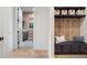 Entryway mudroom with a bench, storage and view of a laundry room through an open doorway at 1616 Turnbull Crossings Dr, New Smyrna Beach, FL 32168