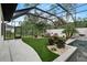 Enclosed patio with artificial turf, seating area, landscaping, and view of the pool at 1616 Turnbull Crossings Dr, New Smyrna Beach, FL 32168
