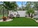 Landscaped patio with artificial turf, lounge chairs, and lush foliage at 1616 Turnbull Crossings Dr, New Smyrna Beach, FL 32168