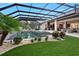 Beautiful outdoor pool with a screened enclosure, lounge chairs, and manicured landscaping at 1616 Turnbull Crossings Dr, New Smyrna Beach, FL 32168