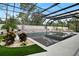 Lush tropical landscaping surrounds a stunning screened in pool and spa at 1616 Turnbull Crossings Dr, New Smyrna Beach, FL 32168