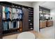 Spacious walk-in closet with custom shelves, hanging rods, and drawers for optimal organization and bathroom view at 1616 Turnbull Crossings Dr, New Smyrna Beach, FL 32168