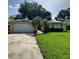 Inviting single-Gathering home with a well-maintained lawn, mature landscaping, and solar panels on the roof at 1743 Jacobs Rd, South Daytona, FL 32119
