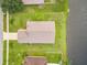 Aerial perspective of a home featuring a large roof, a driveway, manicured lawn, and serene water views at 1809 Forough Cir, Port Orange, FL 32128