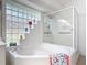 Close up of modern tub and glass enclosed shower with unique block window feature at 1809 Forough Cir, Port Orange, FL 32128