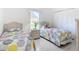 Bright bedroom featuring two twin beds, a white wicker nightstand, and closet at 1809 Forough Cir, Port Orange, FL 32128