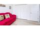 Bright bedroom features white doors, light wood floors, and a vibrant pink couch at 1809 Forough Cir, Port Orange, FL 32128