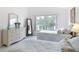 Sunlit bedroom with twin beds, white wicker furniture, and a large window overlooking a peaceful lake at 1809 Forough Cir, Port Orange, FL 32128