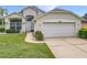 Well-maintained single-Gathering home featuring lush green lawn, arched windows and a two-car garage at 1809 Forough Cir, Port Orange, FL 32128