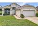 A charming single-Gathering home with a well-manicured lawn, arched window and a two-car garage at 1809 Forough Cir, Port Orange, FL 32128