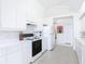 Clean, all-white kitchen features vaulted ceilings, an electric range, and modern appliances at 1809 Forough Cir, Port Orange, FL 32128
