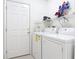 Practical laundry room with washer, dryer and door, providing convenience at 1809 Forough Cir, Port Orange, FL 32128