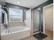 Bathroom features a bathtub with a shower and a window providing natural light at 19 Abacus Ave, Ormond Beach, FL 32174