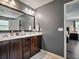 Bathroom features a double sink vanity with dark wood cabinets and a large mirror at 19 Abacus Ave, Ormond Beach, FL 32174