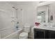 Bright bathroom features a shower-tub combo, single sink vanity with dark cabinets and a large mirror at 19 Abacus Ave, Ormond Beach, FL 32174