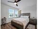 Bright bedroom with a ceiling fan, a large bed, and natural light from two windows at 19 Abacus Ave, Ormond Beach, FL 32174