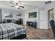 This bedroom has wood flooring, a ceiling fan, a large bed and a TV at 19 Abacus Ave, Ormond Beach, FL 32174