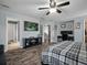 This bedroom has wood flooring, a ceiling fan, a large bed, a TV, and a desk at 19 Abacus Ave, Ormond Beach, FL 32174
