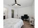 Bright bedroom features a ceiling fan, light hardwood floors, and a desk with office chair at 19 Abacus Ave, Ormond Beach, FL 32174