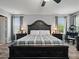 This bedroom has a large bed with a plaid blanket and two windows at 19 Abacus Ave, Ormond Beach, FL 32174