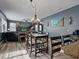 Open-concept dining room adjacent to living area with breakfast bar and wood-look flooring at 19 Abacus Ave, Ormond Beach, FL 32174
