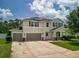 Two-story home showcasing a three-car garage, solar panels, and well-maintained landscaping at 19 Abacus Ave, Ormond Beach, FL 32174