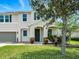 Two story home with a well manicured lawn, mature landscaping, and charming front porch entrance at 19 Abacus Ave, Ormond Beach, FL 32174