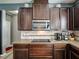 A closer view of the kitchen with dark wood cabinetry and modern appliances, including an electric cooktop at 19 Abacus Ave, Ormond Beach, FL 32174