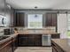 Kitchen with dark wood cabinets, stainless steel appliances, and a view of the backyard through the window at 19 Abacus Ave, Ormond Beach, FL 32174