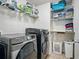 Laundry room features updated washer and dryer, wire shelving, and tiled floors at 19 Abacus Ave, Ormond Beach, FL 32174