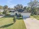 Single-story home boasting an attached garage, mature trees, and lush green lawn at 1929 Pioneer Trl, New Smyrna Beach, FL 32168