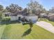 Well-maintained single-story home with a spacious yard, long driveway, and attached garage at 1929 Pioneer Trl, New Smyrna Beach, FL 32168