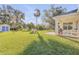 Expansive backyard featuring lush green lawn, storage shed, and mature trees at 1929 Pioneer Trl, New Smyrna Beach, FL 32168