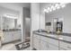 Dual bathroom vanities featuring white cabinets, granite countertops and ample lighting with decorative rugs at 1929 Pioneer Trl, New Smyrna Beach, FL 32168