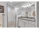 Clean bathroom with a glass shower enclosure, granite countertop and modern light fixtures at 1929 Pioneer Trl, New Smyrna Beach, FL 32168