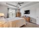 The main bedroom features a ceiling fan and exterior windows and a tv at 1929 Pioneer Trl, New Smyrna Beach, FL 32168
