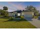 Beautiful single-story home with lush green lawn, a two-car garage, and fresh landscaping at 1929 Pioneer Trl, New Smyrna Beach, FL 32168