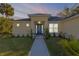 Charming home featuring a blue front door, well-maintained landscaping, and a welcoming walkway at 1929 Pioneer Trl, New Smyrna Beach, FL 32168