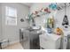 Laundry room featuring a modern washer and dryer, sink, shelves, and ample storage space at 1929 Pioneer Trl, New Smyrna Beach, FL 32168