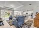 Open-concept living room with tile floors, access to the patio, and an adjacent kitchen at 1929 Pioneer Trl, New Smyrna Beach, FL 32168
