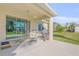 Covered patio with sliding glass doors leads to outdoor grill area and landscaped backyard at 1929 Pioneer Trl, New Smyrna Beach, FL 32168