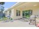 Covered patio with outdoor seating and grill area is perfect for entertaining and relaxation at 1929 Pioneer Trl, New Smyrna Beach, FL 32168