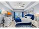 This bedroom features a bright blue tufted headboard, soft lighting, and balcony access at 2 Oceans West Blvd # 608, Daytona Beach Shores, FL 32118