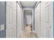 Hallway with multiple closets featuring modern laminate floors and neutral paint at 2 Oceans West Blvd # 608, Daytona Beach Shores, FL 32118