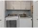 Convenient laundry room with white cabinets and modern washer and dryer units at 2 Oceans West Blvd # 608, Daytona Beach Shores, FL 32118
