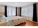 Sunlit bedroom featuring hardwood floors, large windows with bright curtains, and a floral pattern bedspread at 20 N Halifax Ave, Daytona Beach, FL 32118